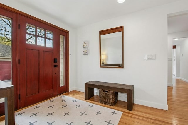 foyer entrance featuring baseboards and wood finished floors