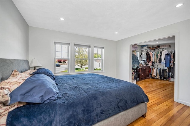 bedroom featuring light wood-style floors, recessed lighting, and a spacious closet