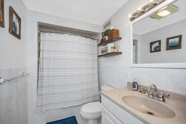 bathroom featuring tile walls, a shower with shower curtain, vanity, toilet, and a wainscoted wall