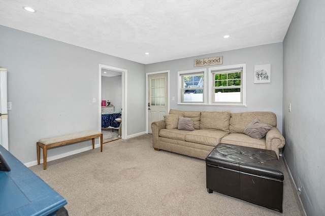 carpeted living area with recessed lighting and baseboards