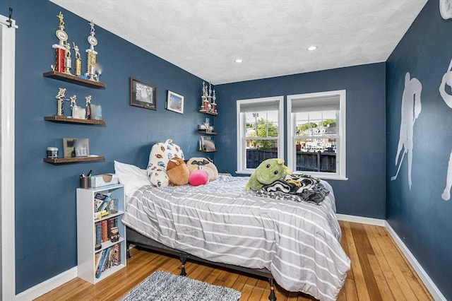 bedroom with wood-type flooring, baseboards, and recessed lighting