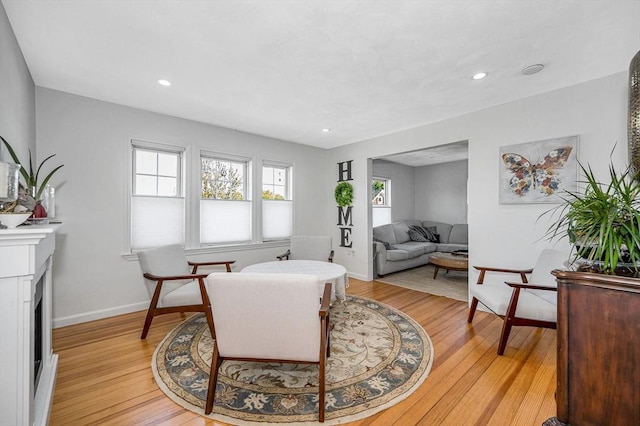 living area featuring light wood-style floors, recessed lighting, baseboards, and a fireplace