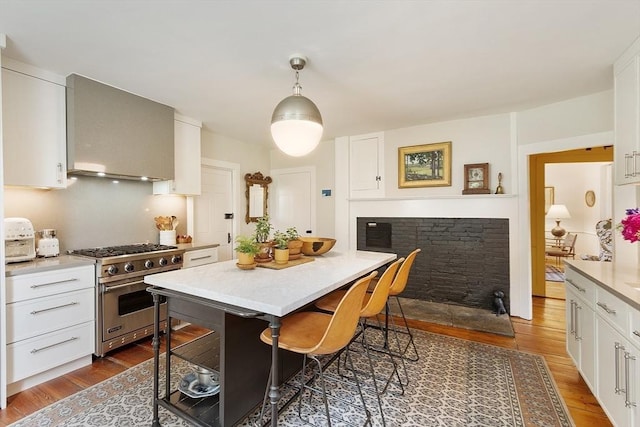 9 The Cmn, Royalston, MA 01368 - kitchen featuring designer range, dark wood-style flooring, white cabinetry, and wall chimney exhaust hood