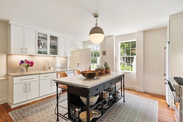 9 The Cmn, Royalston, MA 01368 - kitchen featuring light wood finished floors, white cabinetry, glass insert cabinets, light countertops, and pendant lighting