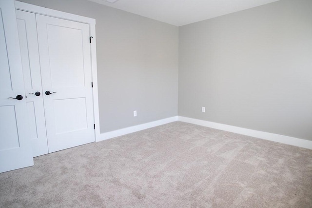 unfurnished bedroom featuring a closet and light carpet