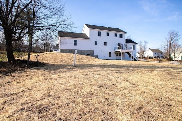 rear view of property with a wooden deck and a yard