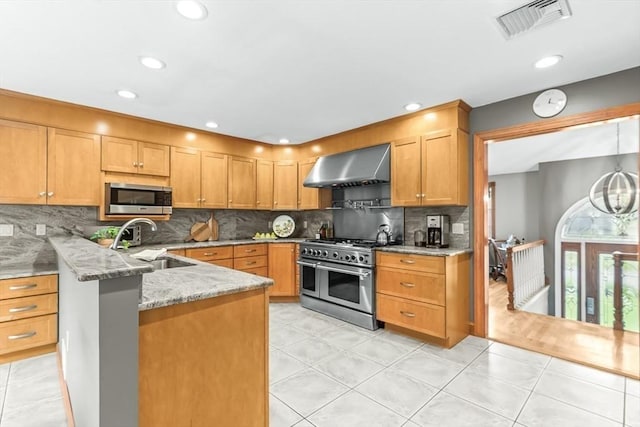 18 Sumac St, Billerica, MA 01821 - kitchen featuring wall chimney range hood, appliances with stainless steel finishes, a sink, light stone countertops, and backsplash
