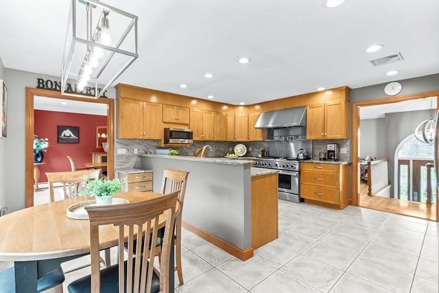 18 Sumac St, Billerica, MA 01821 - kitchen featuring stainless steel appliances, wall chimney range hood, tasteful backsplash, light countertops, and light tile patterned floors