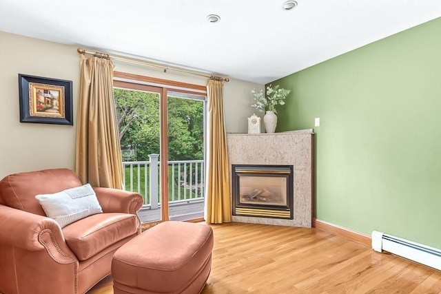 18 Sumac St, Billerica, MA 01821 - living area featuring baseboard heating, wood finished floors, a premium fireplace, and baseboards