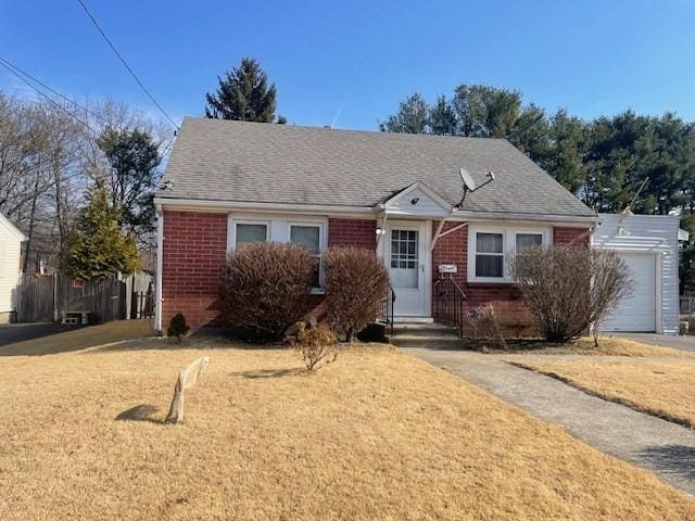 view of front of house with brick siding, a shingled roof, and a front lawn