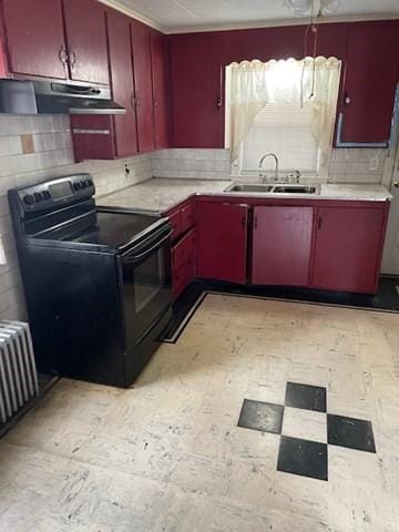 kitchen featuring under cabinet range hood, a sink, black range with electric cooktop, red cabinets, and light countertops