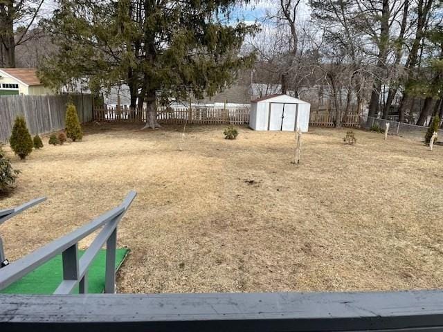 view of yard with an outbuilding, a shed, and a fenced backyard