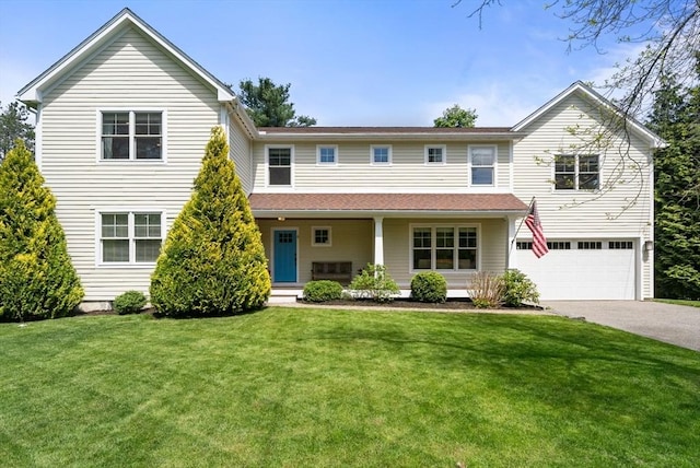 view of front facade with driveway, a garage, a front yard, and covered porch
