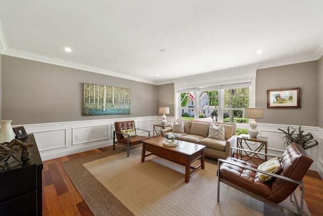living area with ornamental molding, wood finished floors, wainscoting, recessed lighting, and a decorative wall