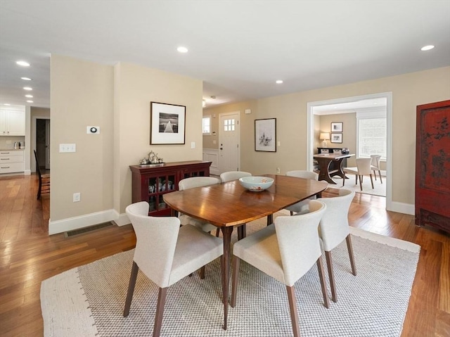 dining room with wood finished floors, baseboards, and recessed lighting