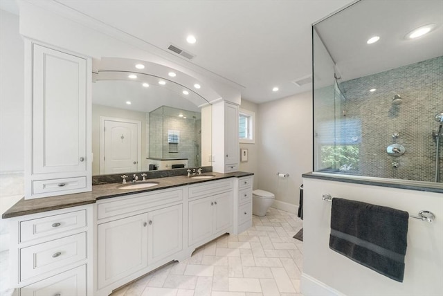 full bathroom with a stall shower, baseboards, toilet, double vanity, and recessed lighting