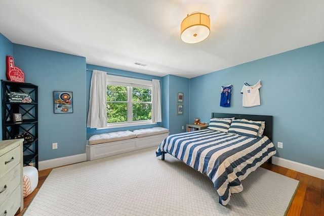 bedroom with baseboards and wood finished floors