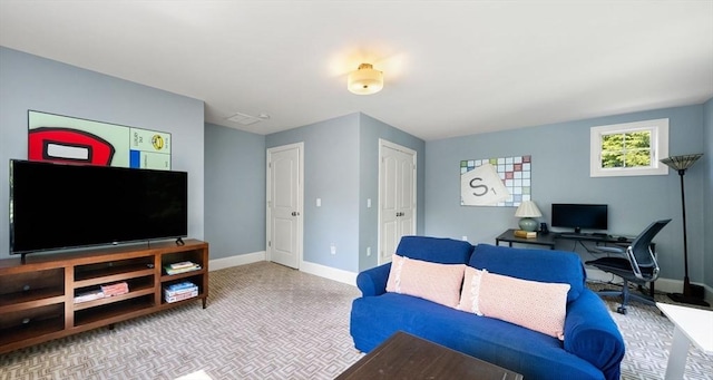 carpeted living room with baseboards and an office area