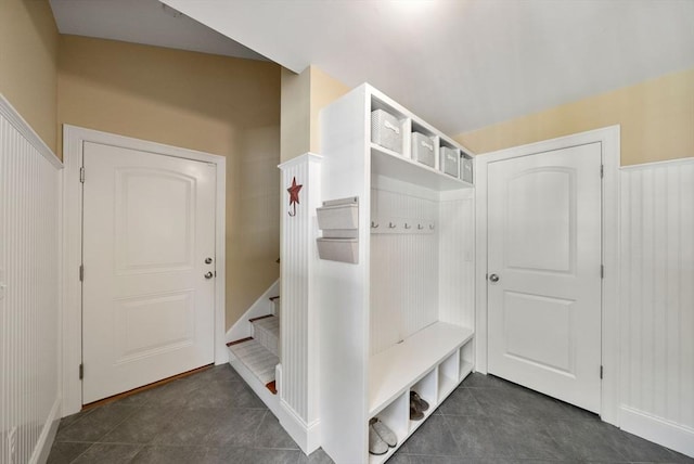 mudroom with dark tile patterned floors and baseboards