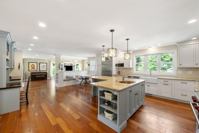 kitchen with appliances with stainless steel finishes, a sink, open floor plan, open shelves, and recessed lighting