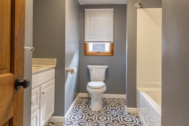 full bath with baseboards, toilet, a bathing tub, tile patterned floors, and vanity