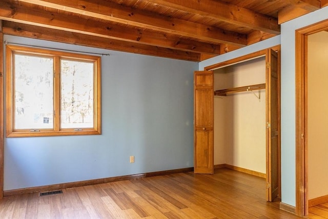 unfurnished bedroom with visible vents, beam ceiling, wooden ceiling, and light wood finished floors