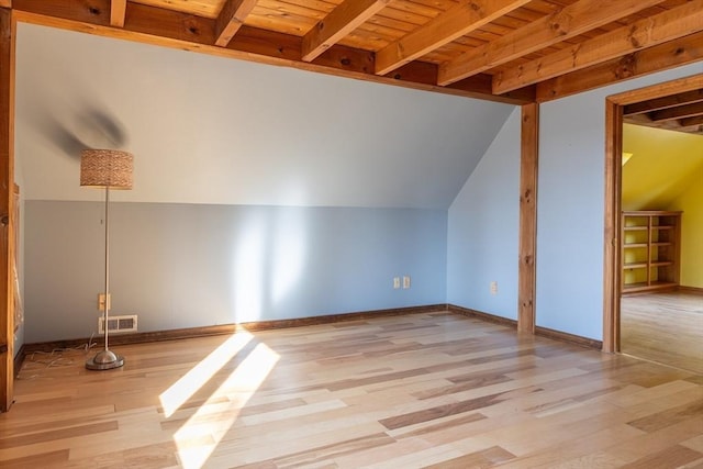 additional living space featuring lofted ceiling with beams, wood finished floors, visible vents, and baseboards