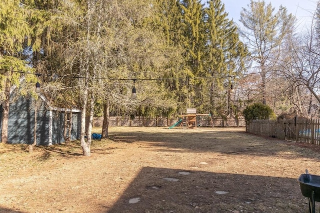 view of yard with a playground and fence