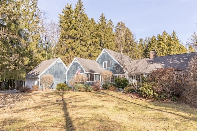 view of front of property with a chimney and a front lawn