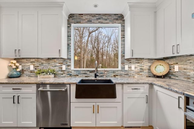 kitchen featuring a sink, tasteful backsplash, white cabinetry, and dishwasher