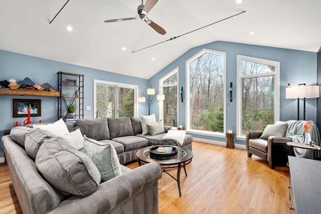 living room featuring light wood-type flooring, plenty of natural light, lofted ceiling, and recessed lighting