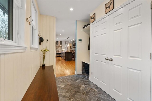 corridor featuring brick floor and recessed lighting