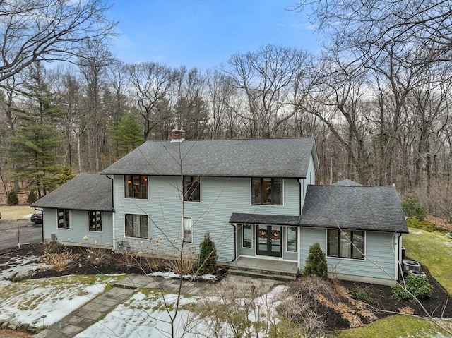 view of front of property featuring a shingled roof, a chimney, and french doors