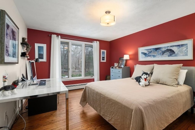 bedroom featuring baseboard heating and wood-type flooring