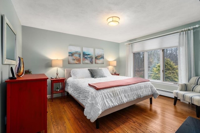 bedroom with hardwood / wood-style flooring and a baseboard radiator