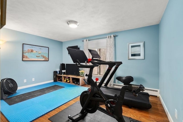 exercise room with baseboards and wood finished floors