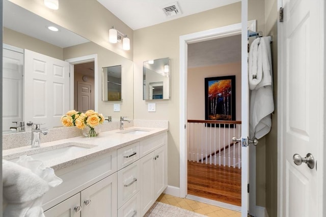 full bath with double vanity, baseboards, a sink, and tile patterned floors