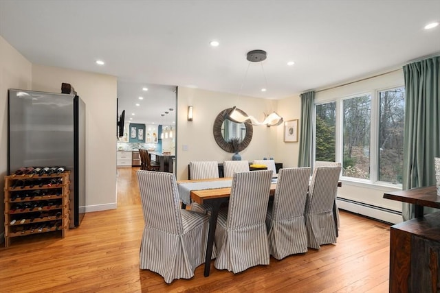 dining area featuring a baseboard heating unit, recessed lighting, and light wood-style flooring