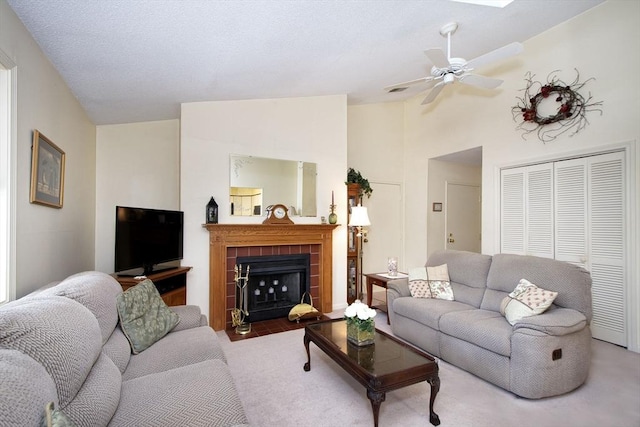 living room featuring lofted ceiling, a fireplace, and a ceiling fan