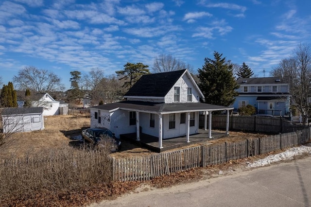 country-style home with a porch and a fenced front yard