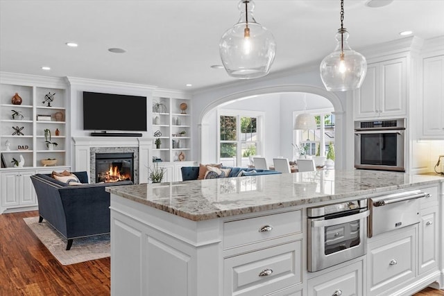 kitchen with white cabinetry, pendant lighting, dark hardwood / wood-style floors, and stainless steel oven