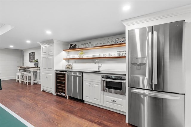 kitchen with sink, dark wood-type flooring, white cabinetry, stainless steel appliances, and wine cooler