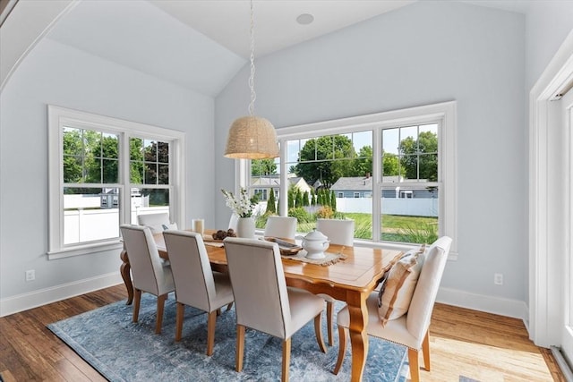 dining area featuring hardwood / wood-style flooring and vaulted ceiling