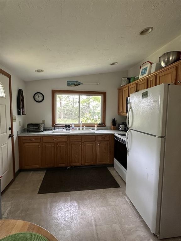 16 Neds Way, Plymouth, MA 02360 - kitchen featuring white appliances, light countertops, and brown cabinets