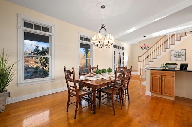 dining area with a notable chandelier and light wood-type flooring