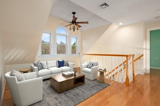 living room with light wood-type flooring, ceiling fan, and lofted ceiling