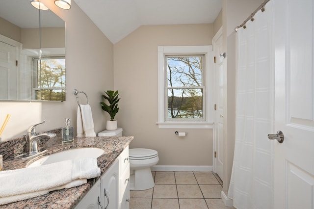 bathroom with tile patterned floors, vanity, toilet, and a wealth of natural light