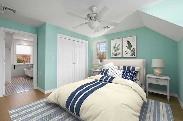 bedroom with multiple windows, ceiling fan, a closet, and hardwood / wood-style floors