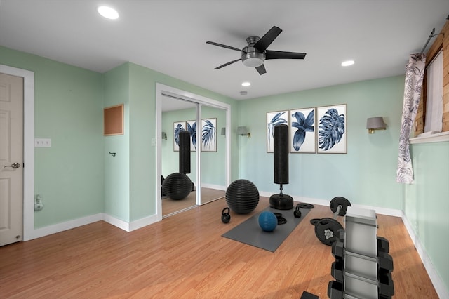 workout area with ceiling fan and light wood-type flooring