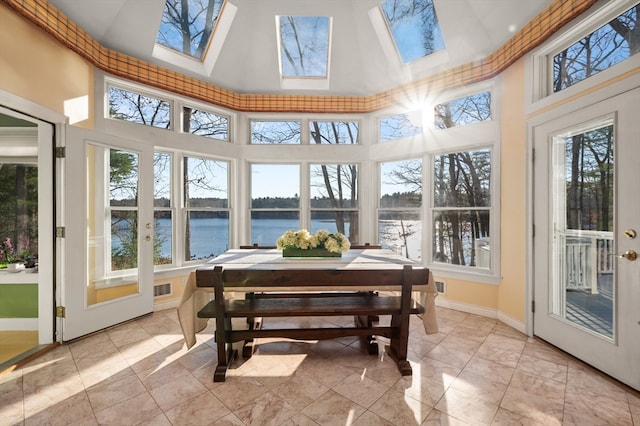 sunroom featuring vaulted ceiling with skylight and a water view